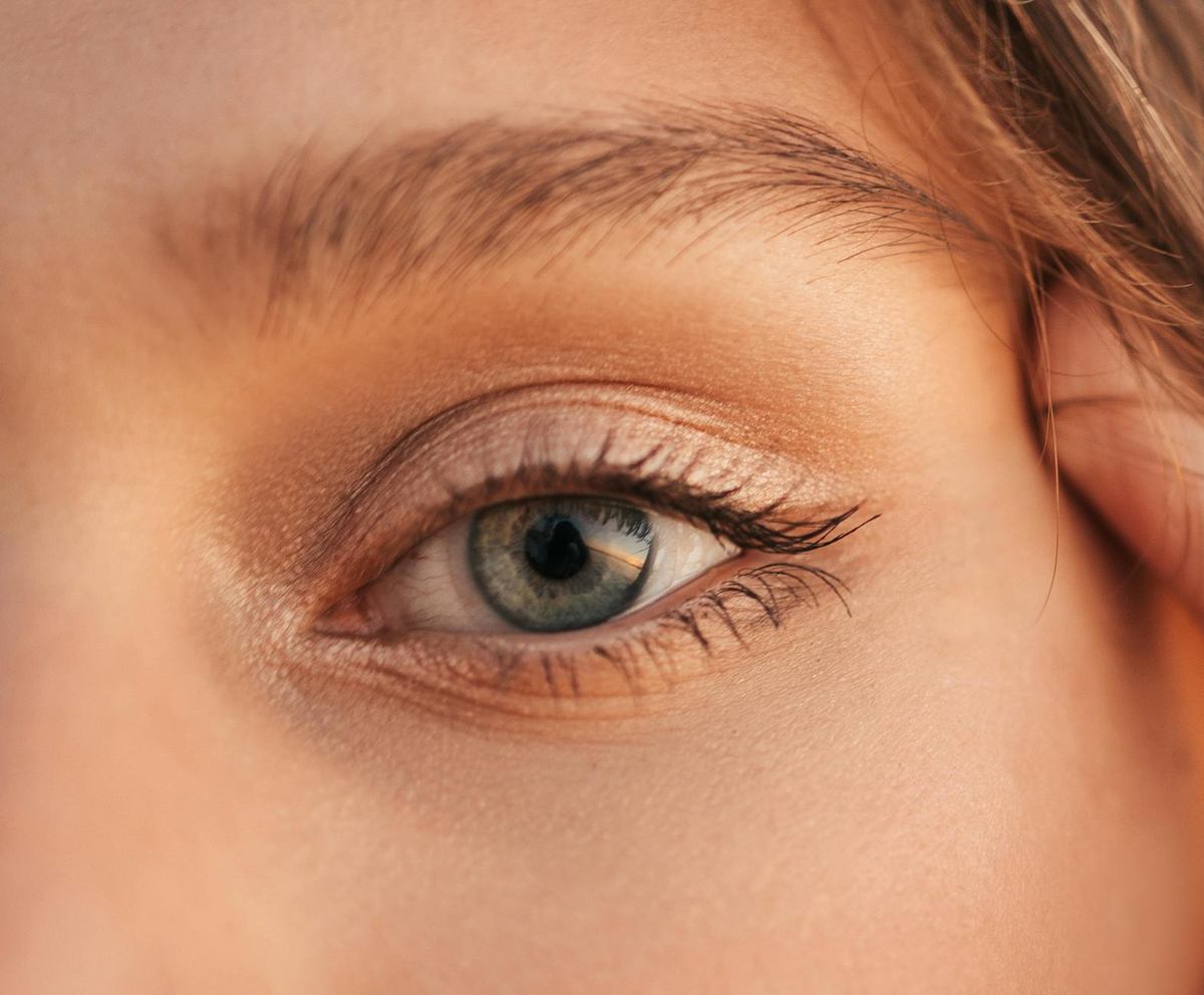 A close-up of a human eye illuminated by an advanced diagnostic device, displaying intricate digital patterns and bio-data overlays that personalize vision health insights.