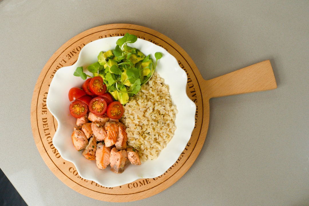 A vibrant, stylized illustration showing glowing mitochondria within a healthy cell, visibly drawing energy and building blocks from surrounding nutrient-dense foods such as avocado, olive oil, fatty fish, and pastured egg yolks.