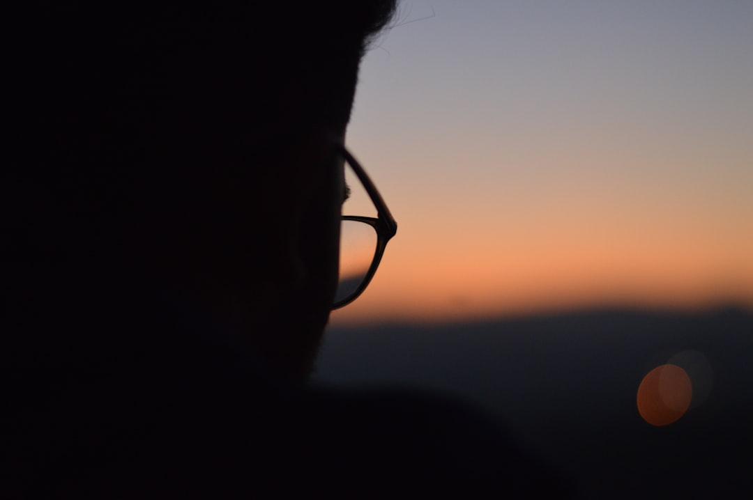 A stylized human head in profile with two subtle, non-invasive electrodes on the scalp, from which faint, glowing electrical currents flow inwards, gently illuminating and subtly affecting a nuanced network of neurons within the brain's cortex.
