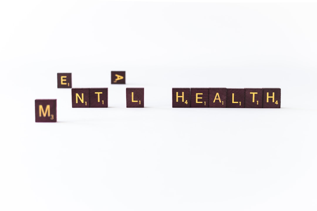 Dark Scrabble tiles spelling MENTAL HEALTH on a crisp white surface symbolize the critical elements of cognitive well-being and brain enhancement.