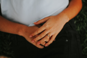 Close-up of a person's hands resting gently on their abdomen, signifying comfort or a contemplative focus on internal well-being and digestive health.