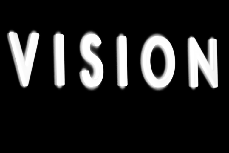The word VISION appears in bold, bright white glowing letters against a stark black background, symbolizing clarity and optimal eye health.