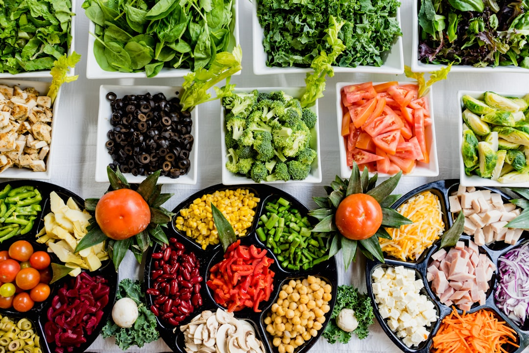 Overhead shot of an abundant salad bar featuring bowls of colorful fresh vegetables, healthy proteins, and fiber-rich legumes, ideal for supporting a healthy gut microbiome.