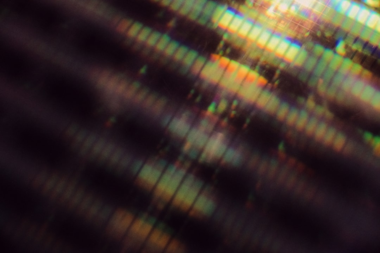 Abstract image of blurred, diagonal bands of rainbow-like light fracturing across a dark background, symbolizing distorted vision or the effects of environmental toxins on eye health.